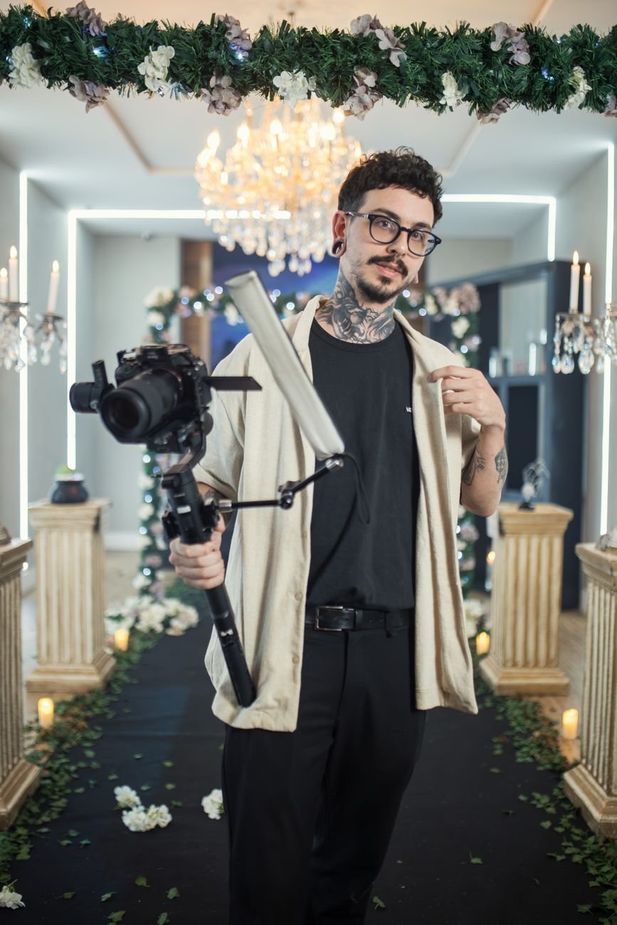 Photographer holding camera gear at an upscale indoor wedding event.