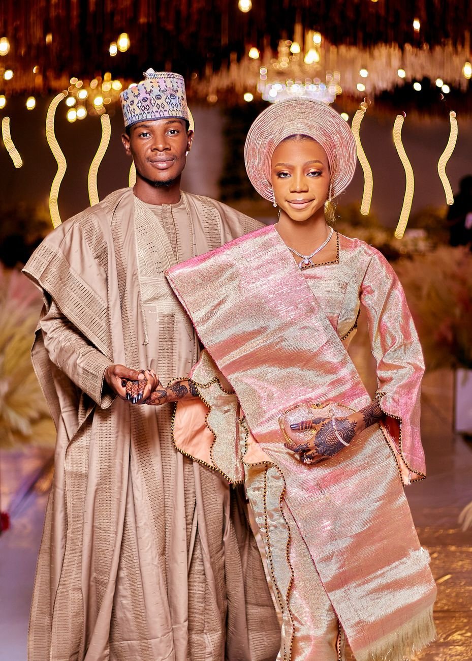 Nigerian couple in traditional attire celebrating at a formal event.